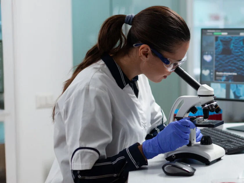 Researcher examining a sample under a microscope in a laboratory